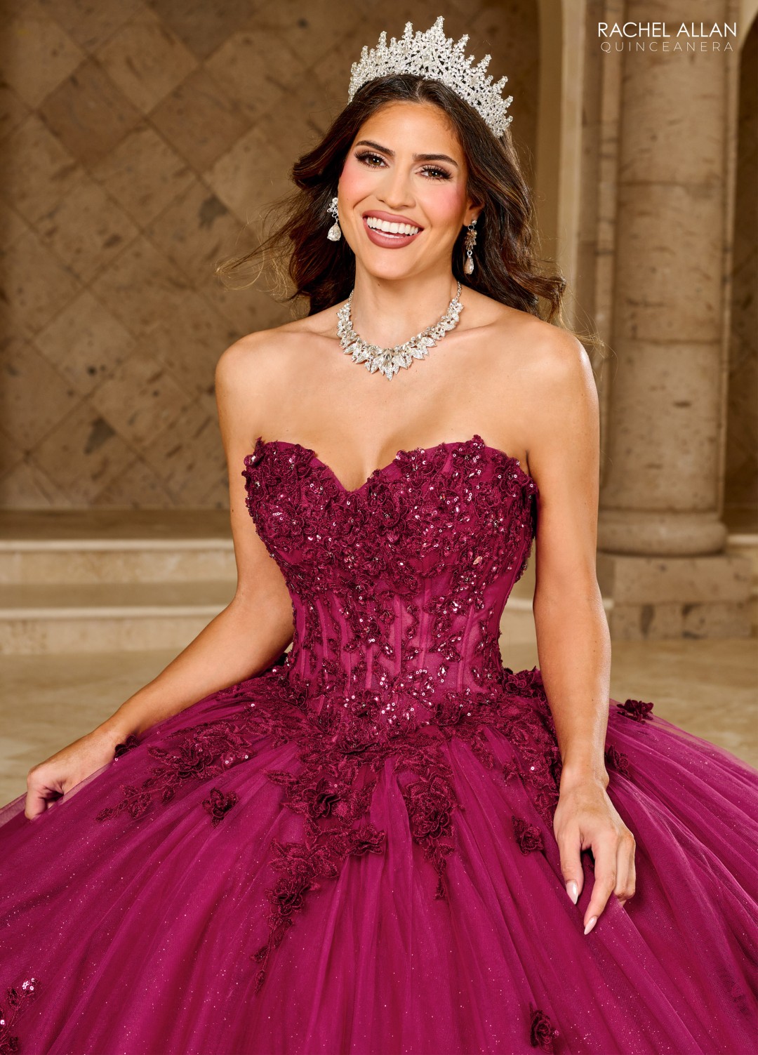 Burgundy strapless quinceañera gown with sequin floral appliqués and long train