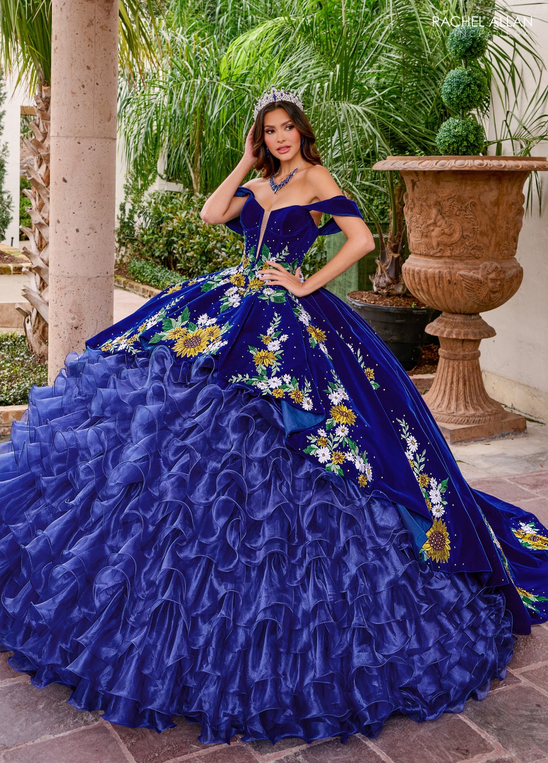 Navy charro-inspired quinceañera gown with gold embroidery and off-shoulder detail