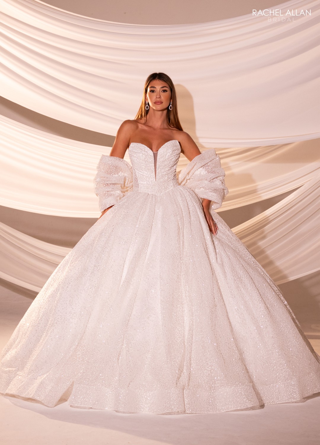 Fitted bridal gown with lace overlay and sheer train detailing