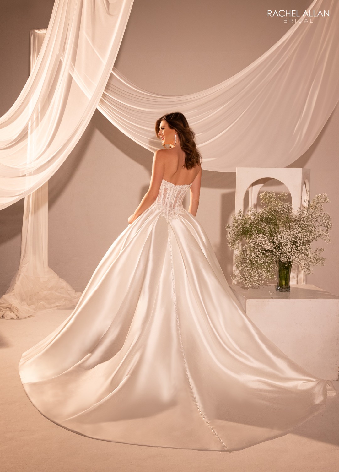 1.	Rachel Allan Style RB2215 sweetheart A-line bridal dress in mikado with corset-style bodice, delicate applique, and oversized bow